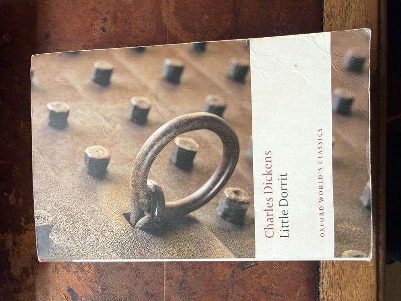 Robbie's copy of Little Dorrit by Charles Dickens, an Oxford World's Classics paperback. The cover photograph shows a heavy iron ring set into a studded wooden door.